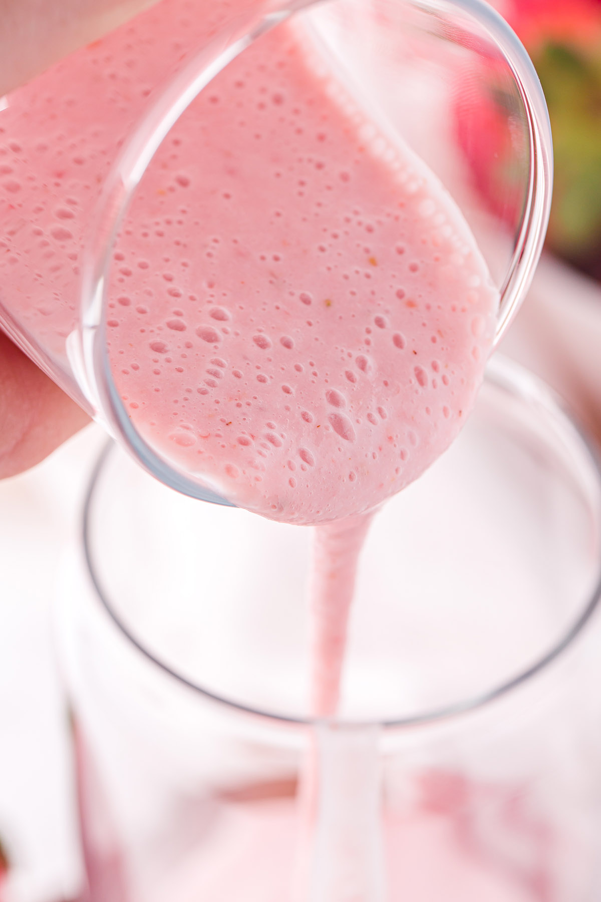 pouring strawberry milk into the glass