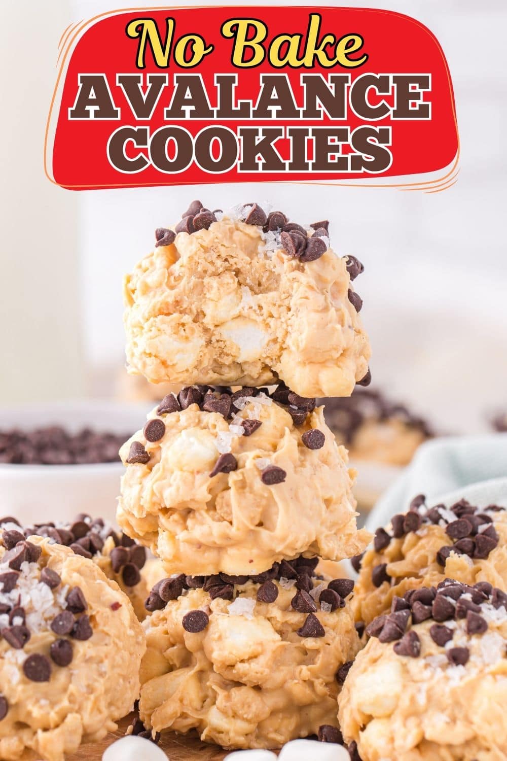 Three no bake avalanche cookies stacked on top of each other with a bite taken out of the top cookie.