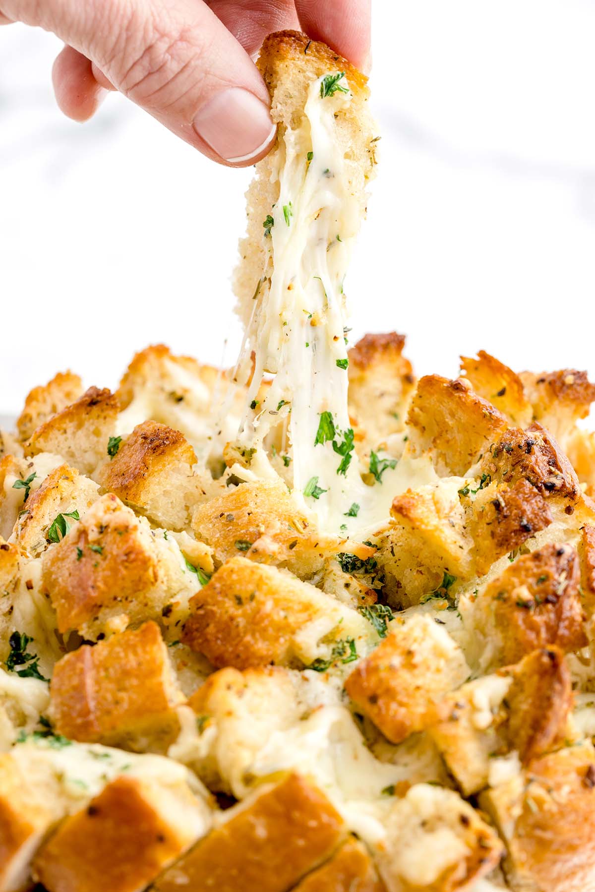 hand is pulling the cheesy bread