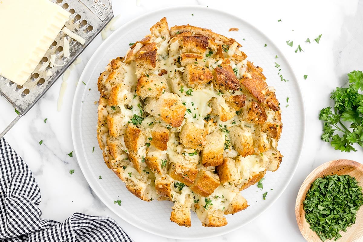 cheesy pull apart bread on a white plate