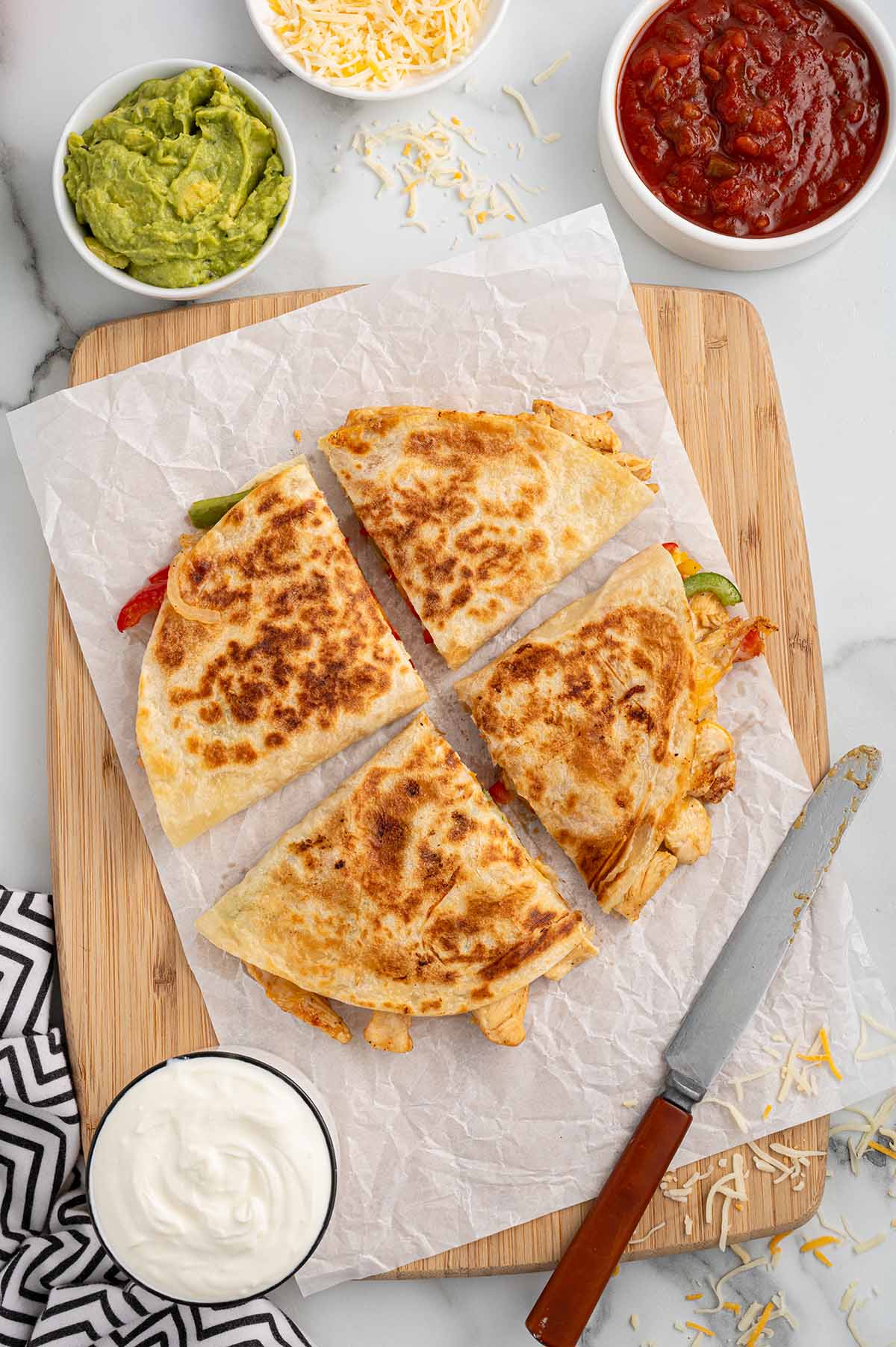 4 slices of fajita quesadillas on top of chopping board. 