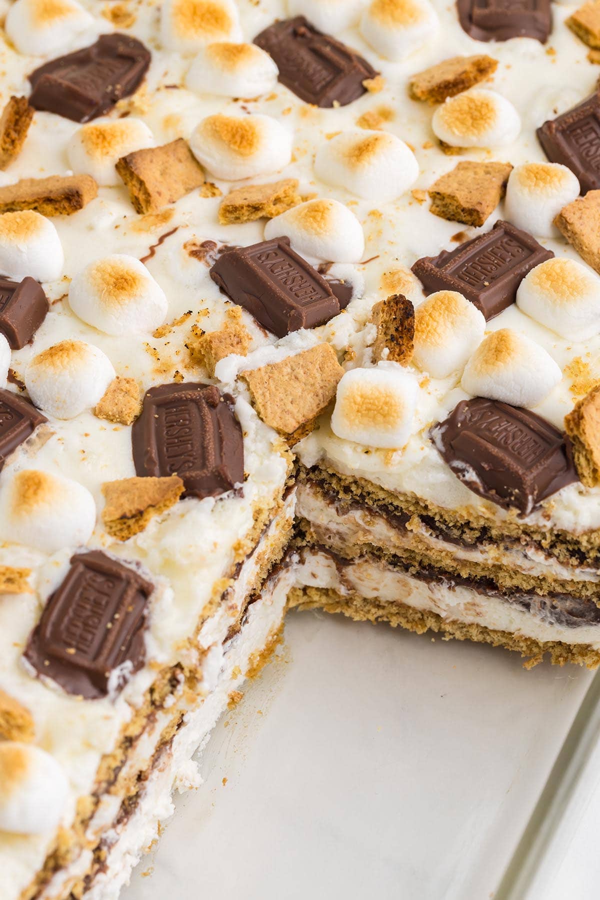 cutting a rectangle piece of smores icebox cake from carrousel dish.