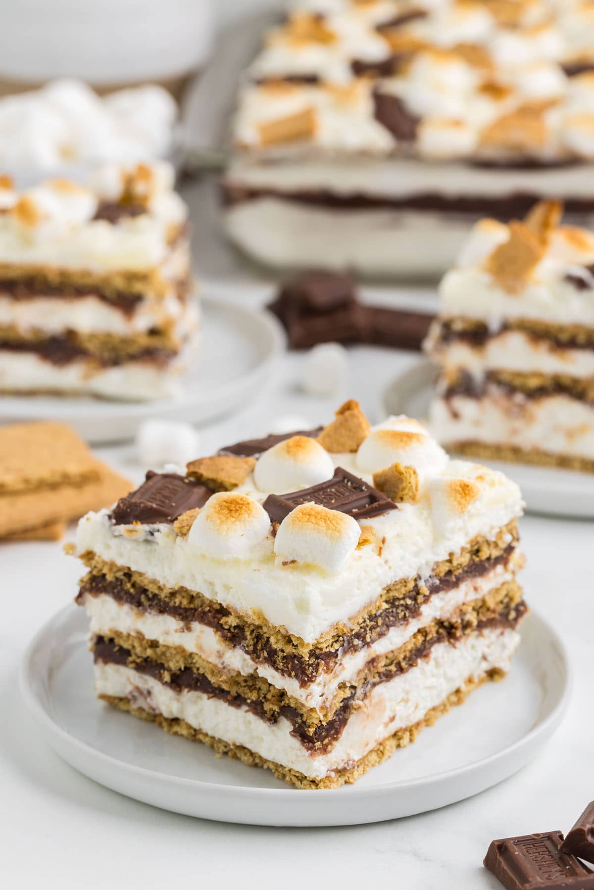a slice of smores icebox cake on a plate with burnt smores on the top.