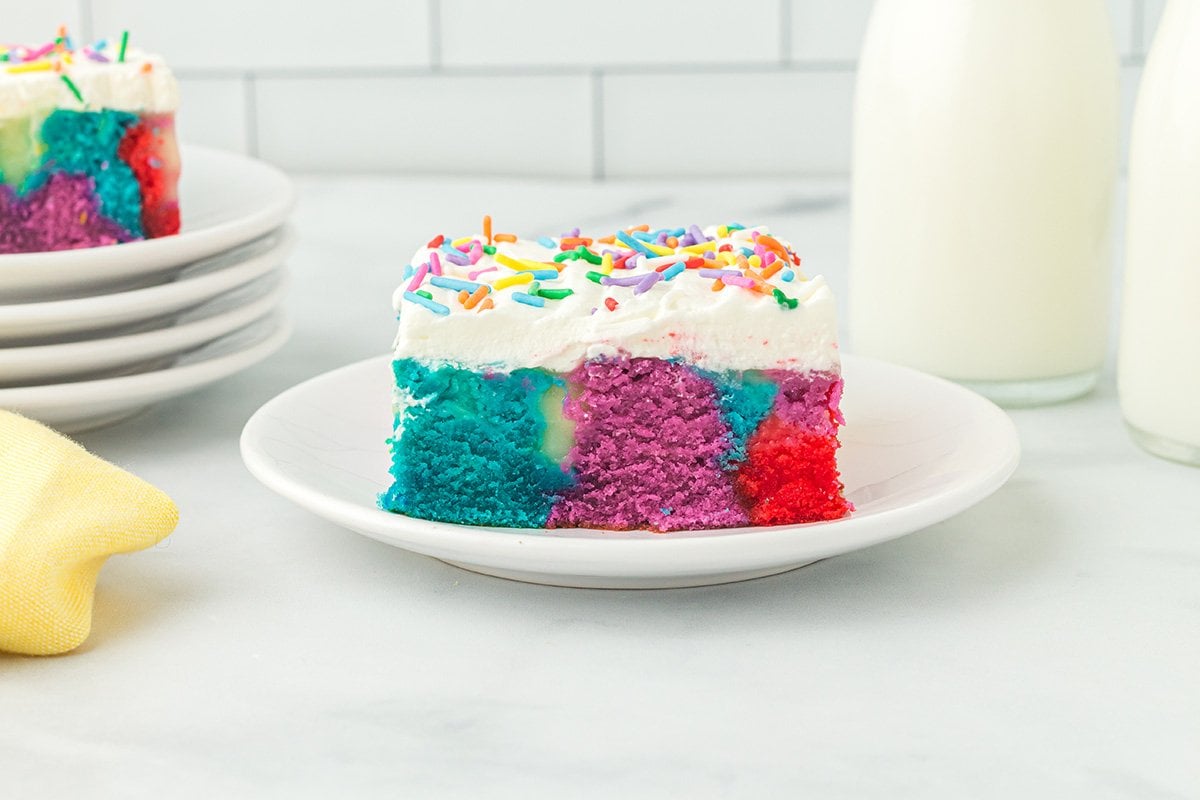 poke rainbow cake on a plate