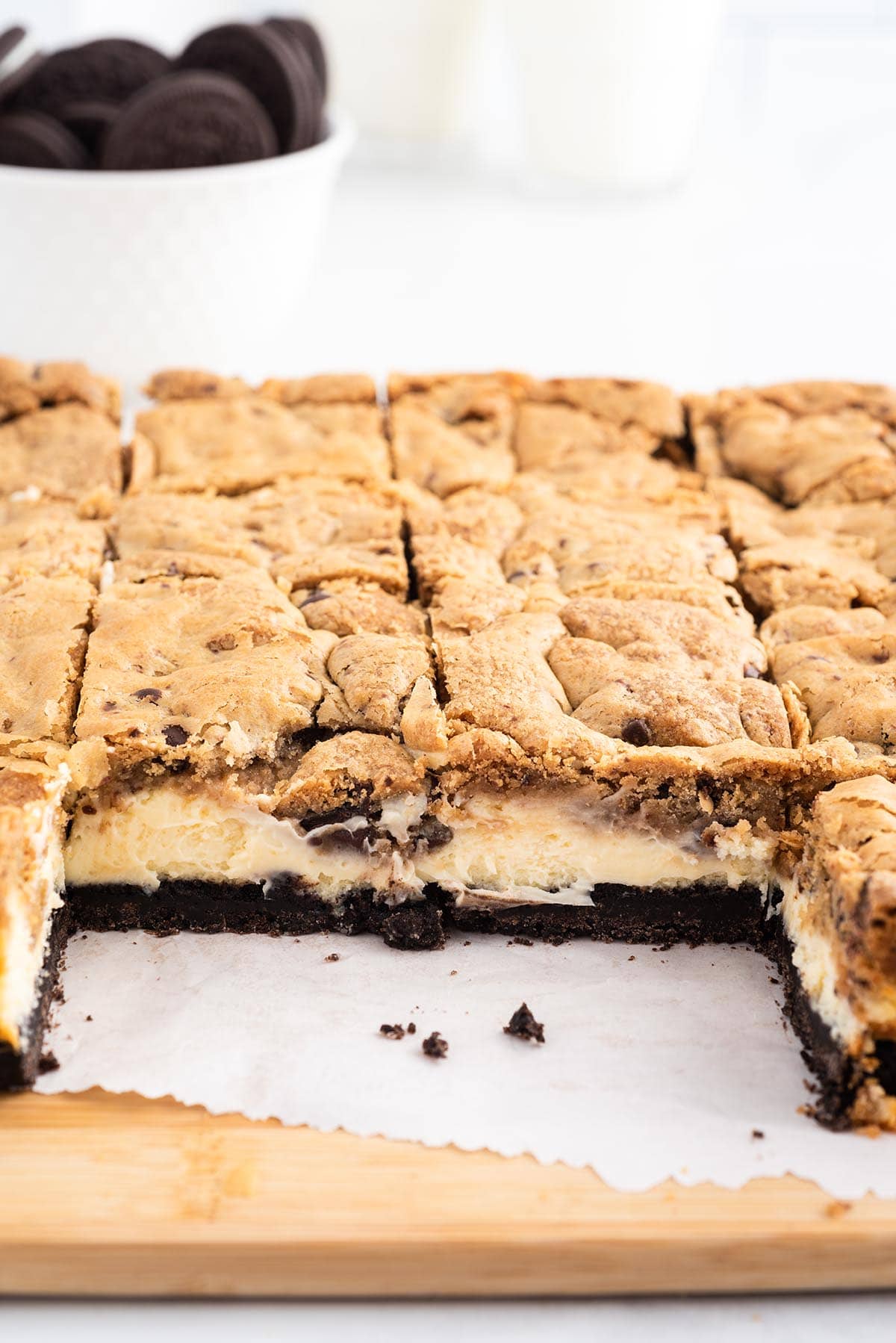 Oreo Chocolate Chip Cheesecake Cookie Bars in a pan cut into squares