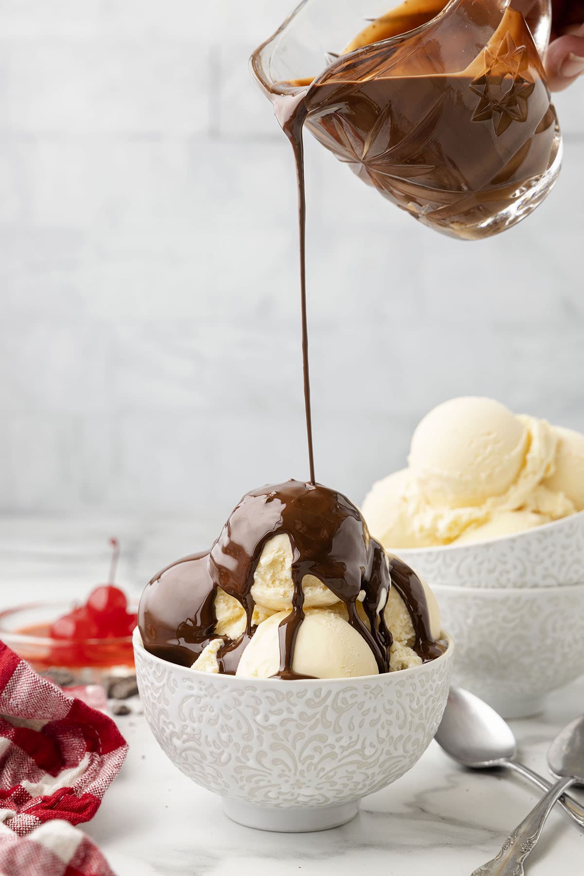 pouring dark chocolate on top of ice cream