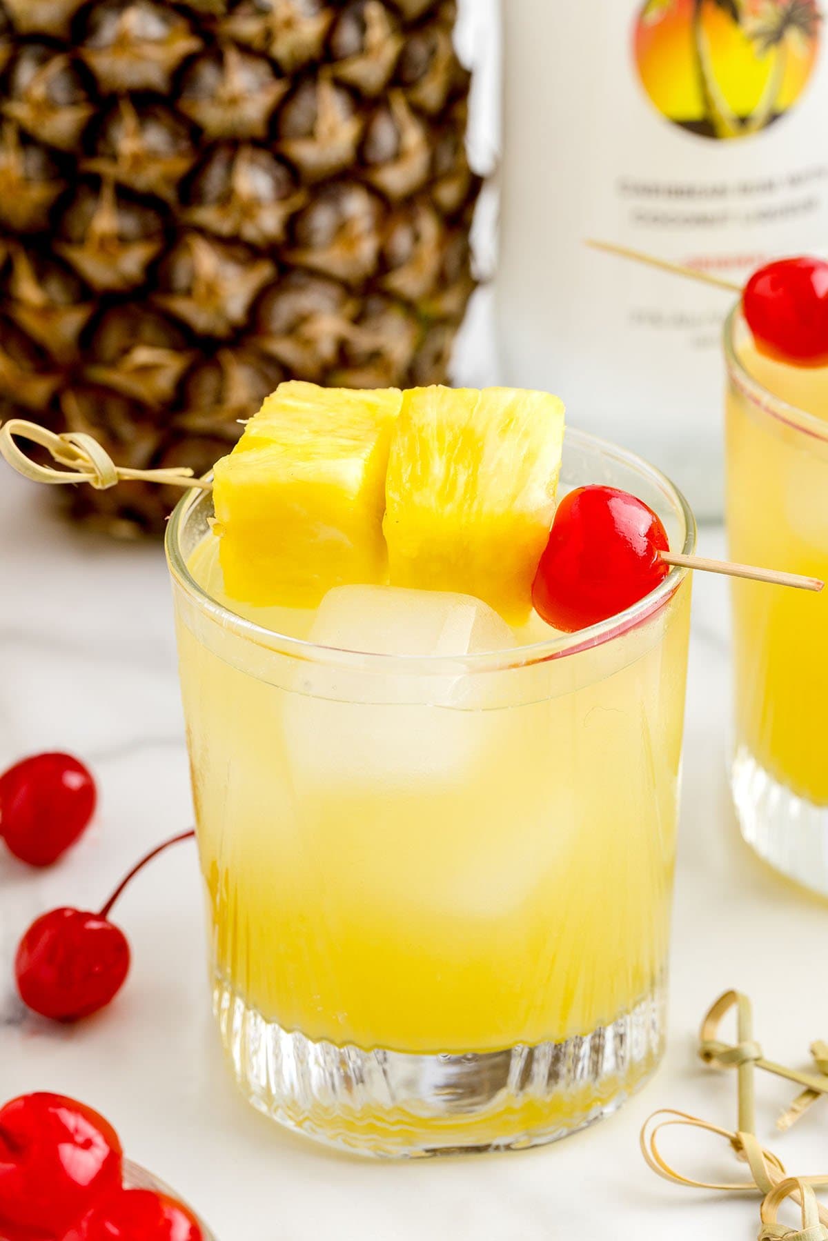 pineapple rum punch with pineapple chunk on a stick