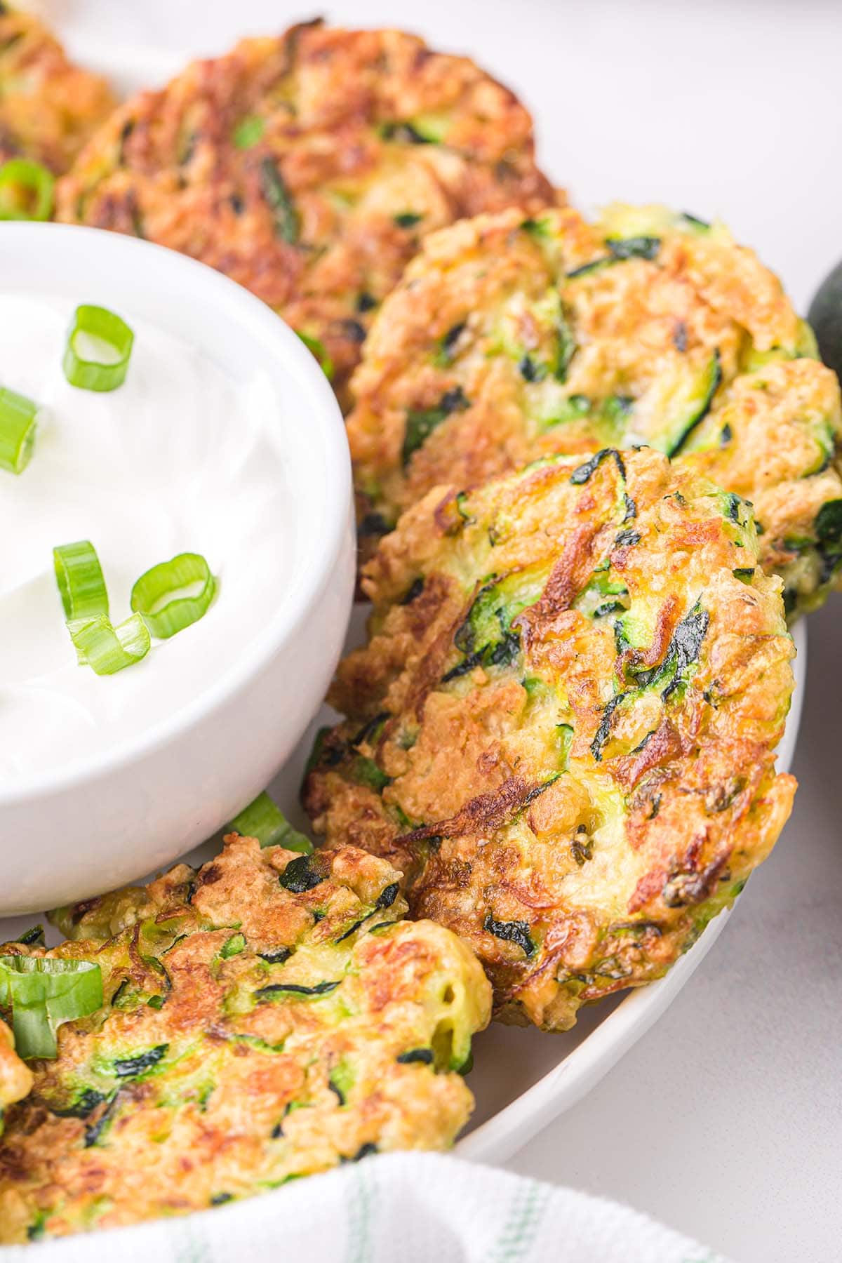 serving zucchini fritters with sour cream