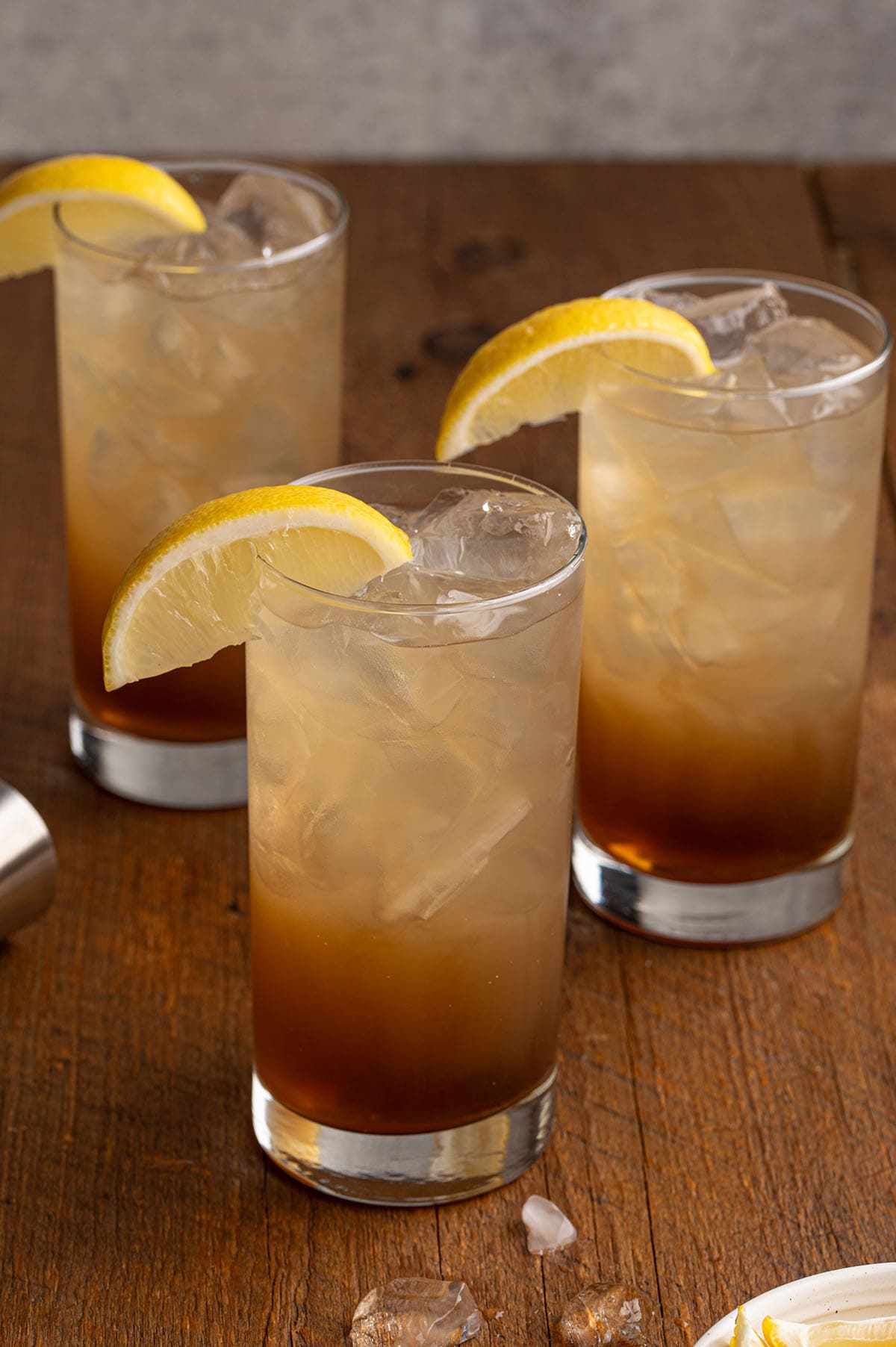 3 glasses of texas tea on top of wooden table. 