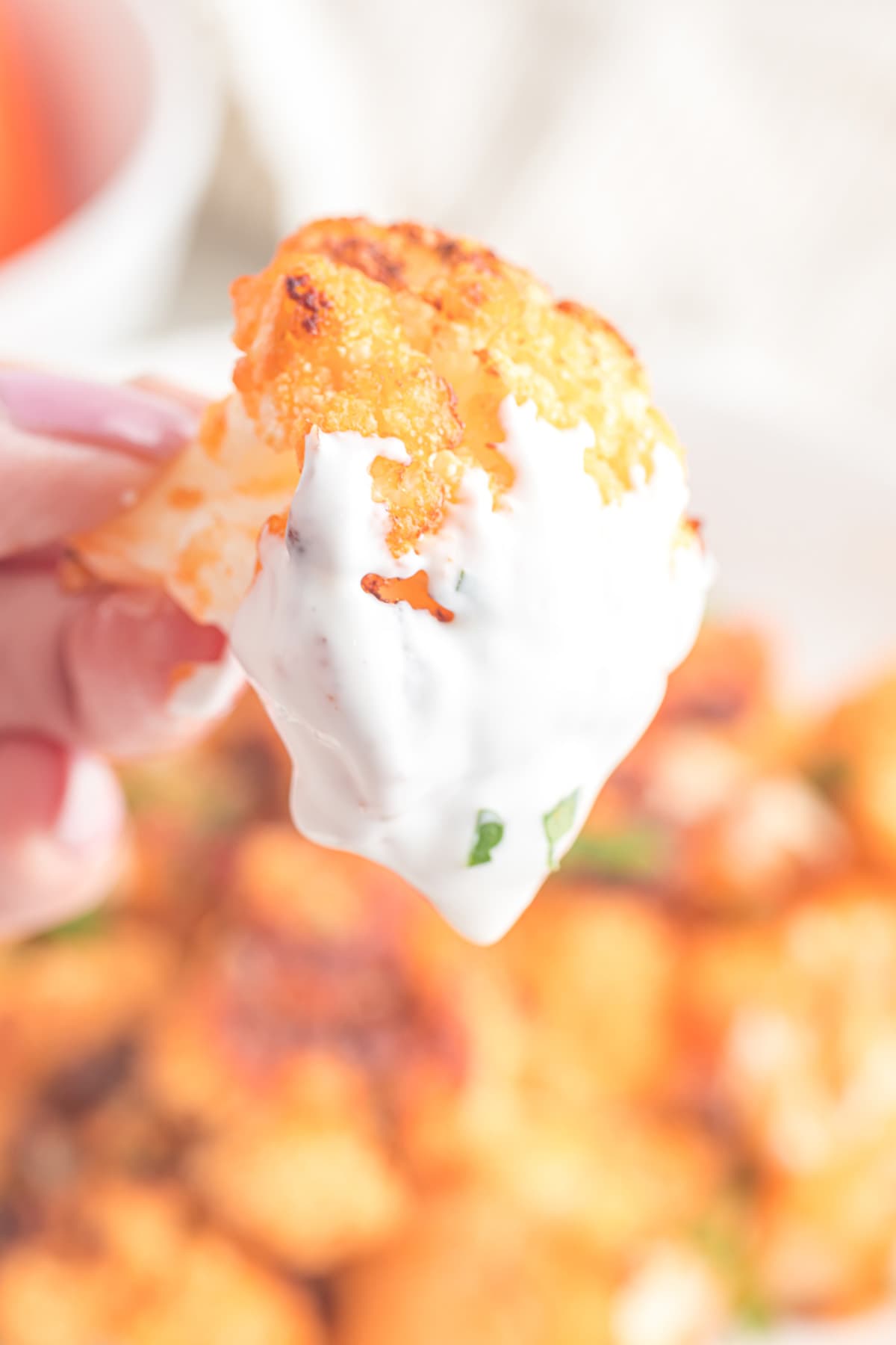 dipping cauliflower into the sour cream