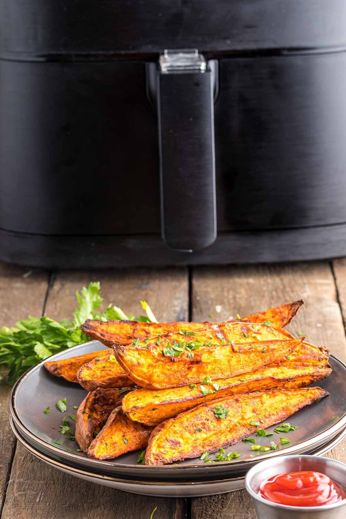 Air Fryer Sweet Potato Wedges in front of air fryer