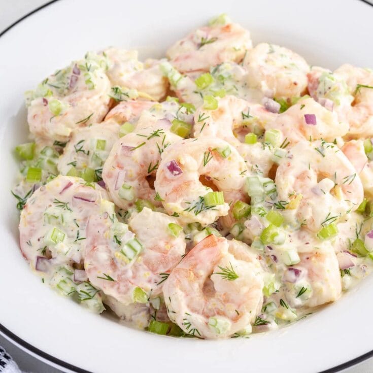 Creamy shrimp salad with shrimp, celery, red onion, and fresh dill served in a white bowl.