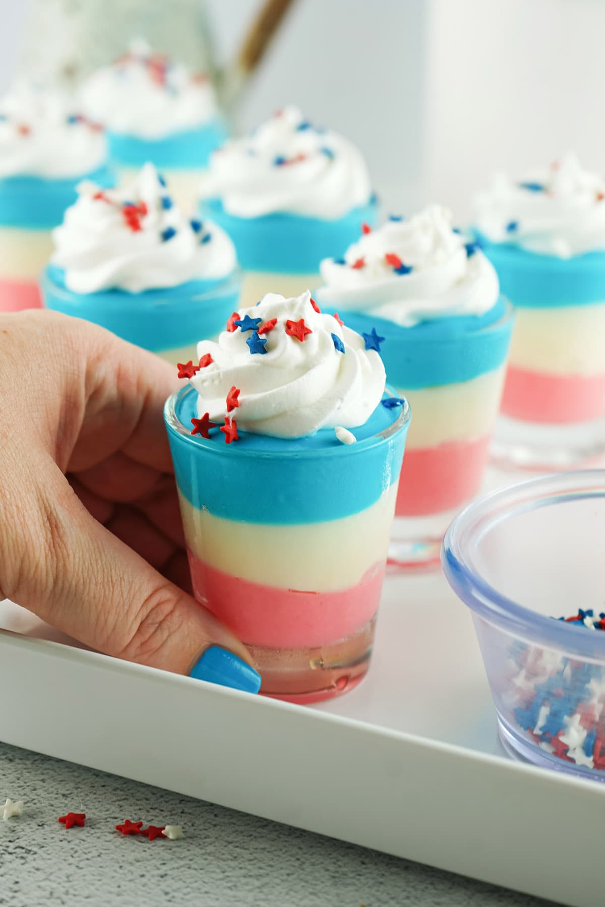 hand holding Red White and Blue Cheesecake Pudding Shots