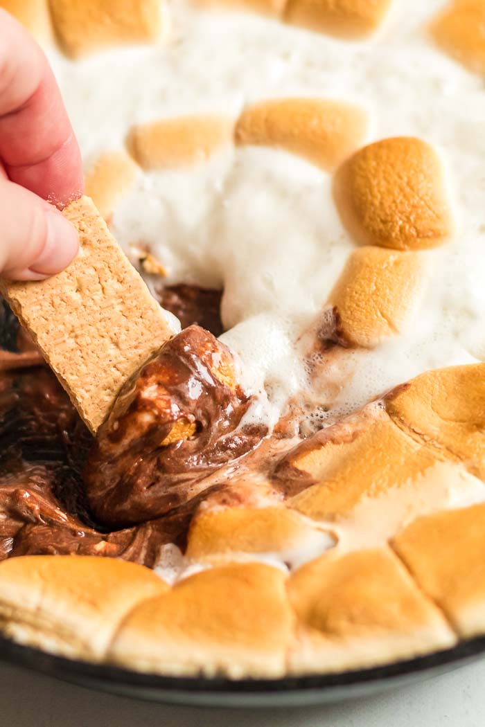 dipping graham crackers in smores dip