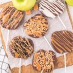 caramel apple slices on top of wooden board.