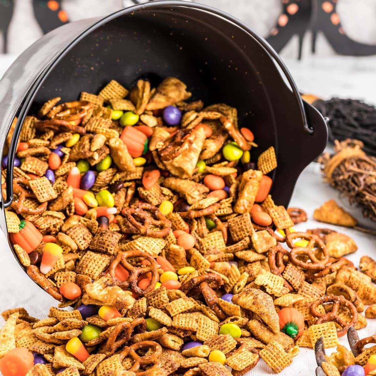 Halloween chex mix spilled out on a table from a bowl