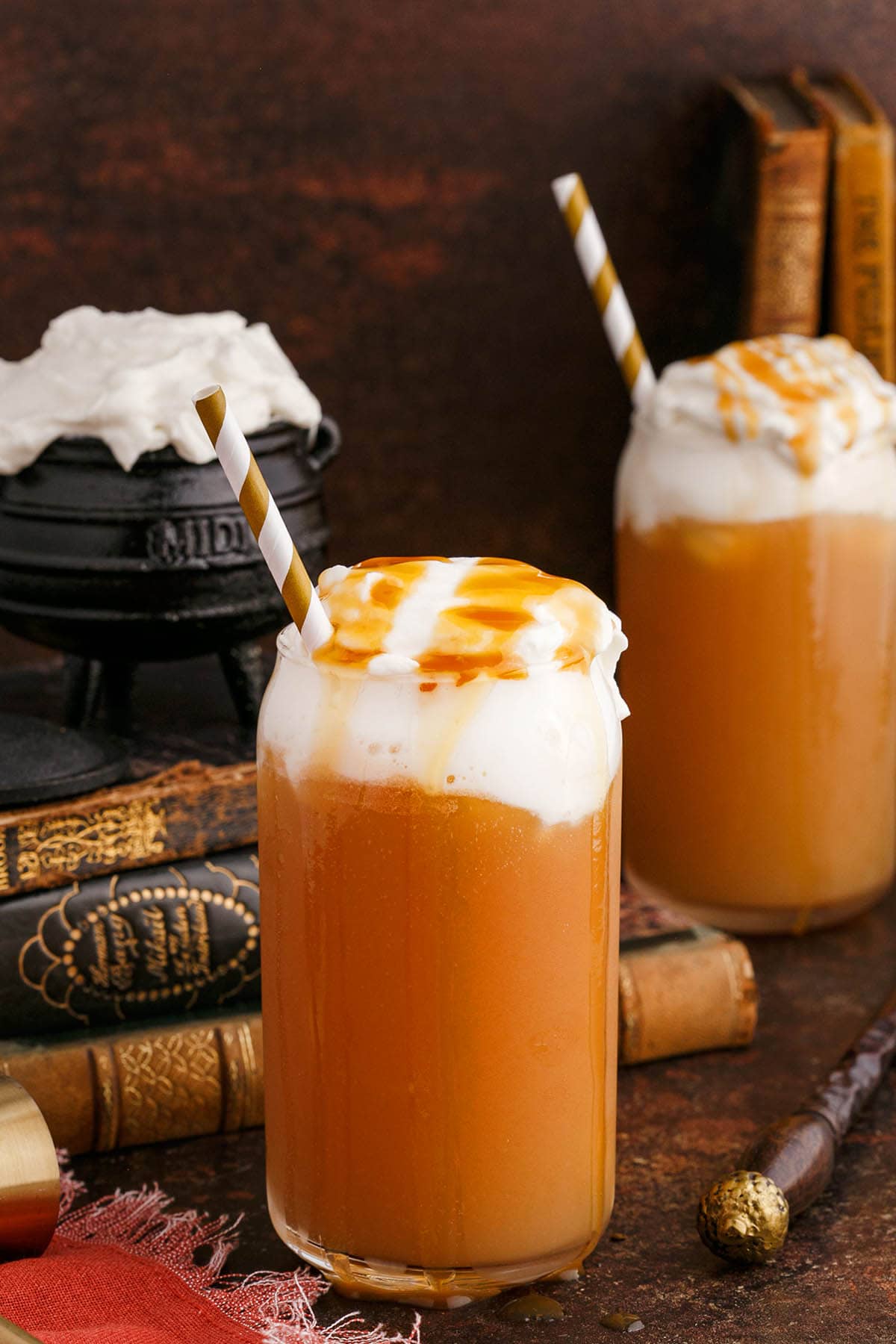 two glasses of Alcoholic Butterbeer topped with whipped cream.