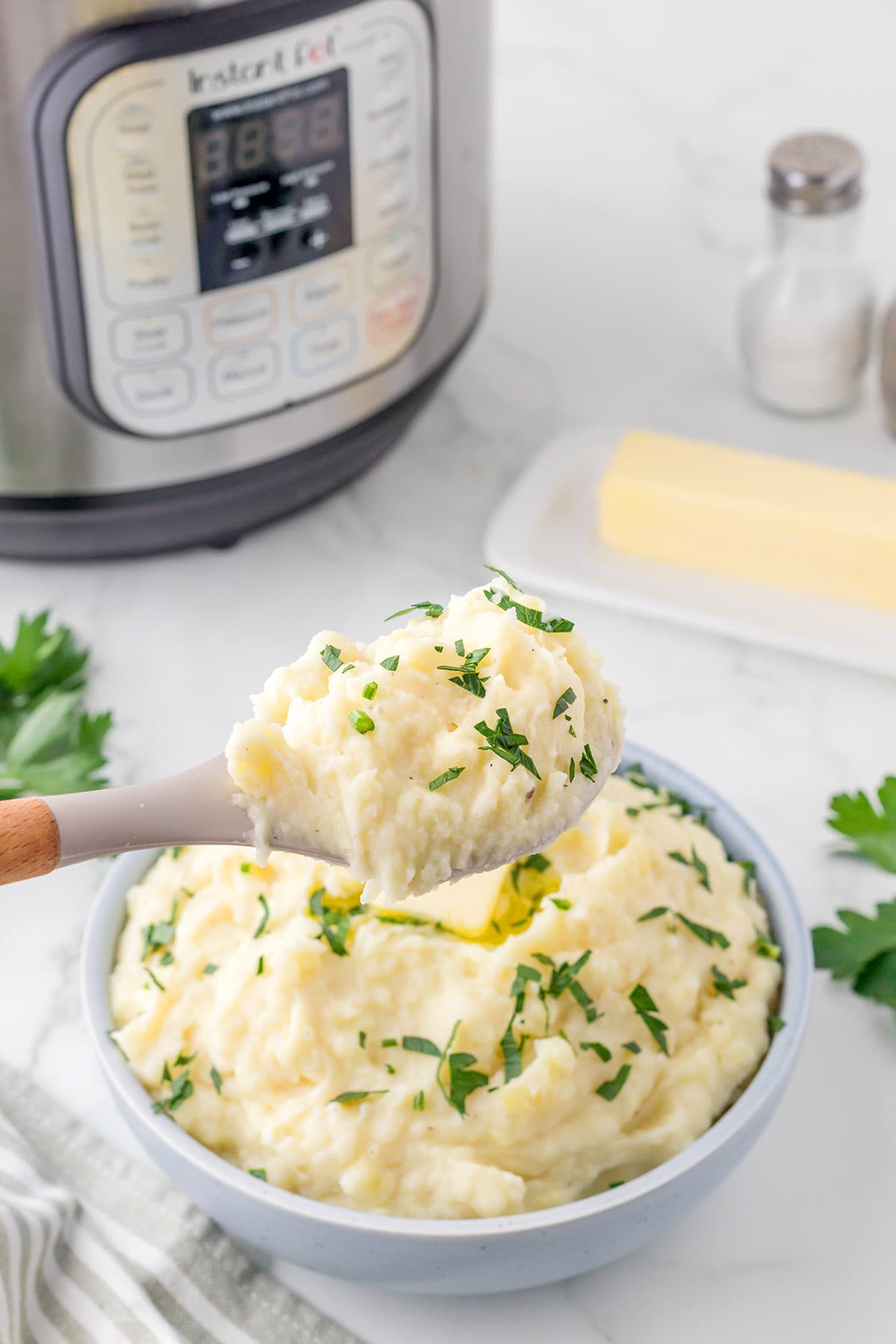 serving Instant Pot Cheesy Mashed Potatoes in a bowl