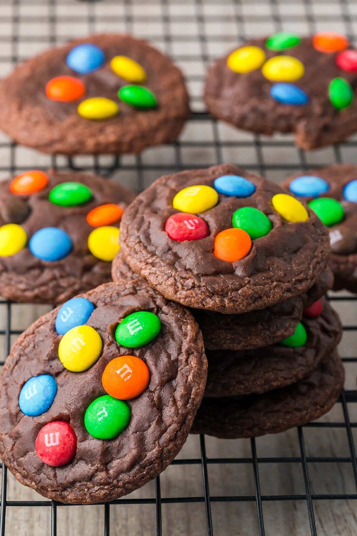 M&M Brownie Mix Cookies stacked up on a cooling rack