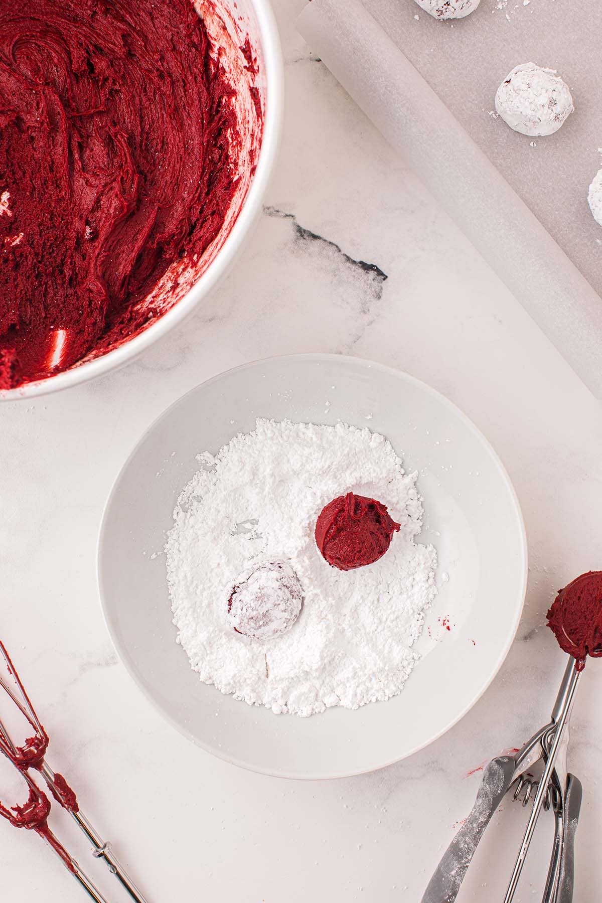 scoop the cookie dough into balls and roll in powdered sugar.