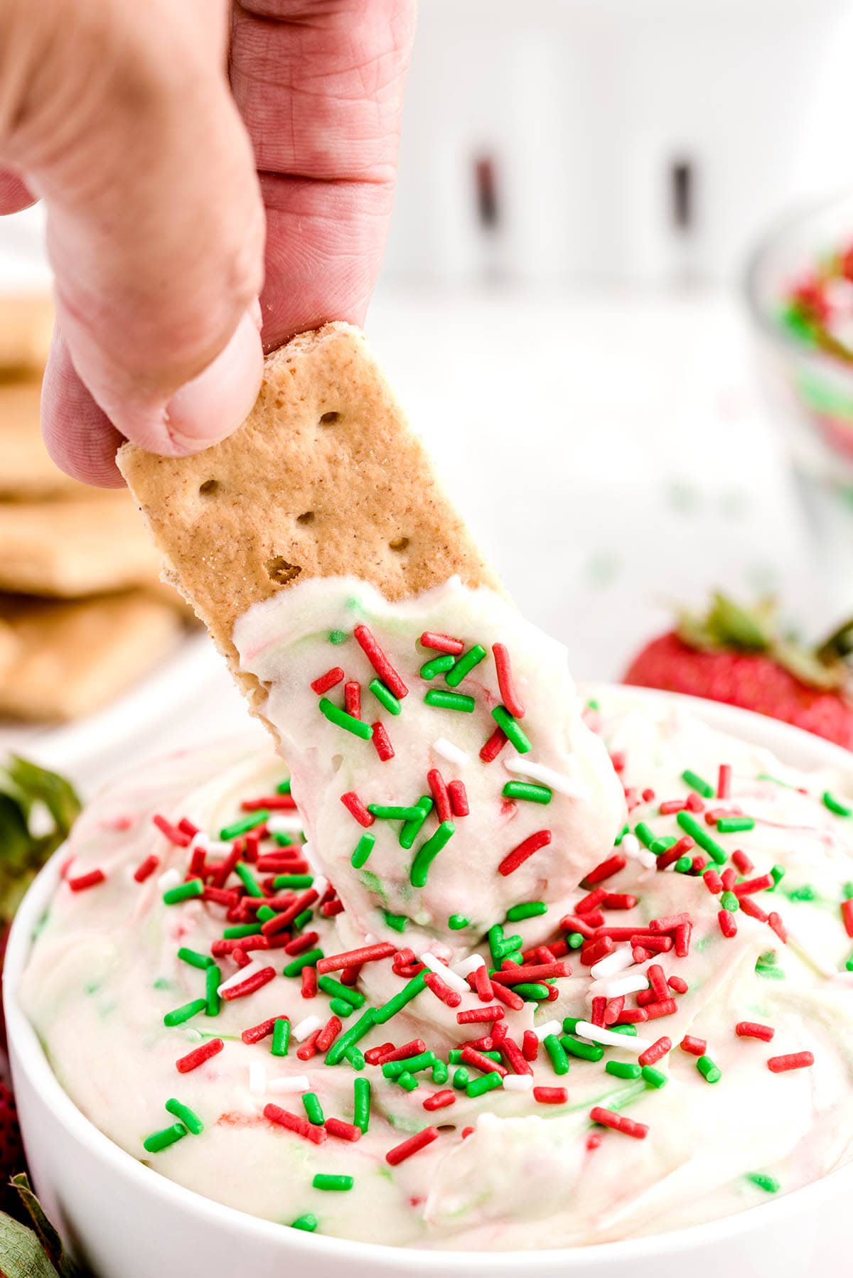 dipping crackers into christmas sugar cookie dip