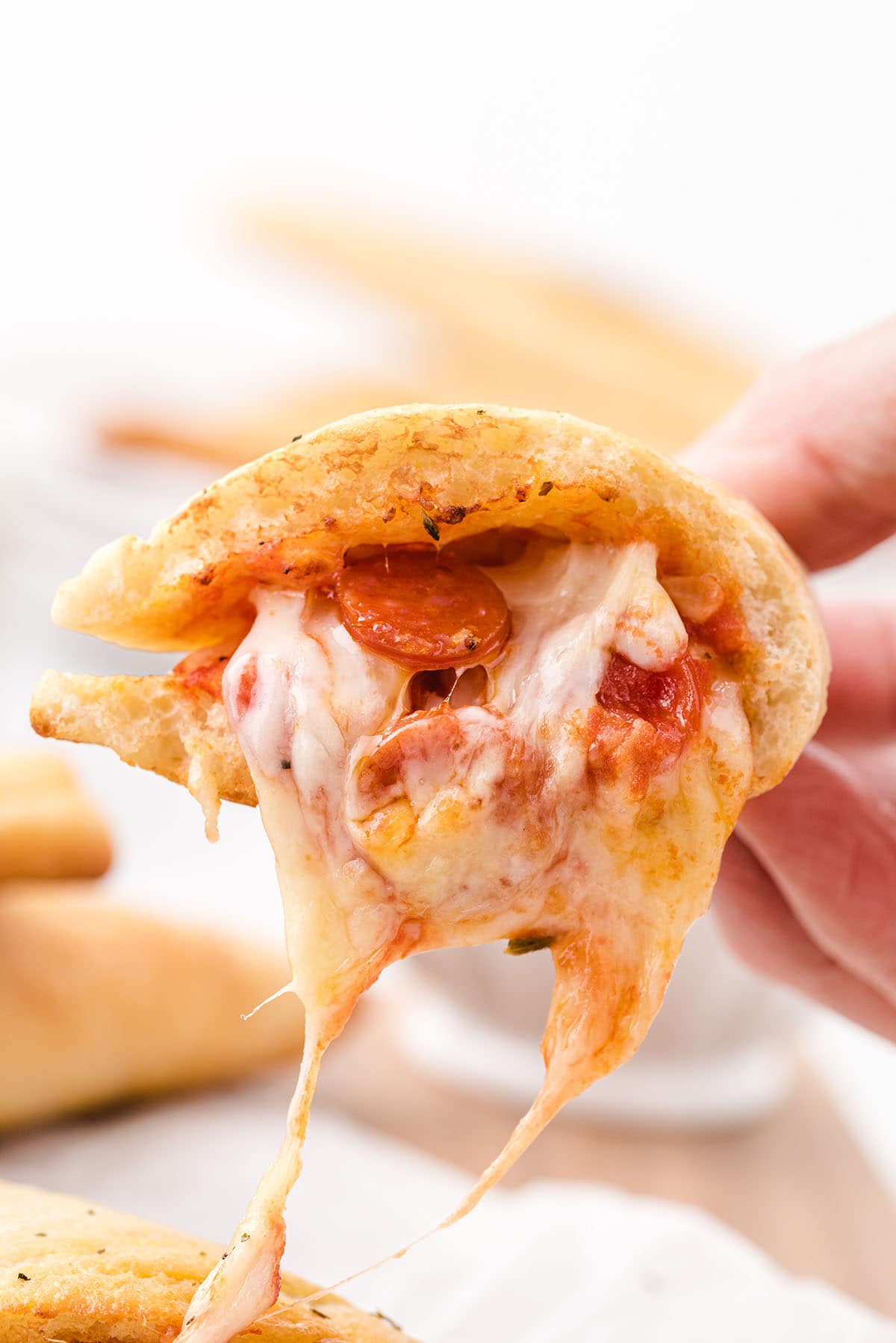 hand holding pizza pockets. 