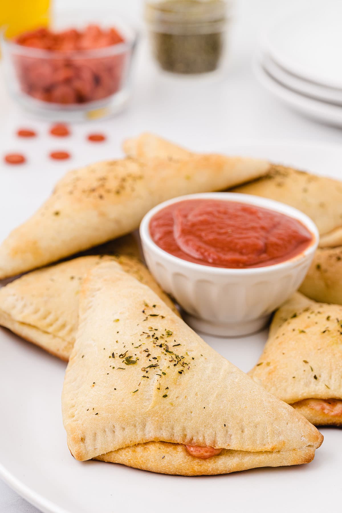 a couple pizza pockets on top of plate served with sauce. 