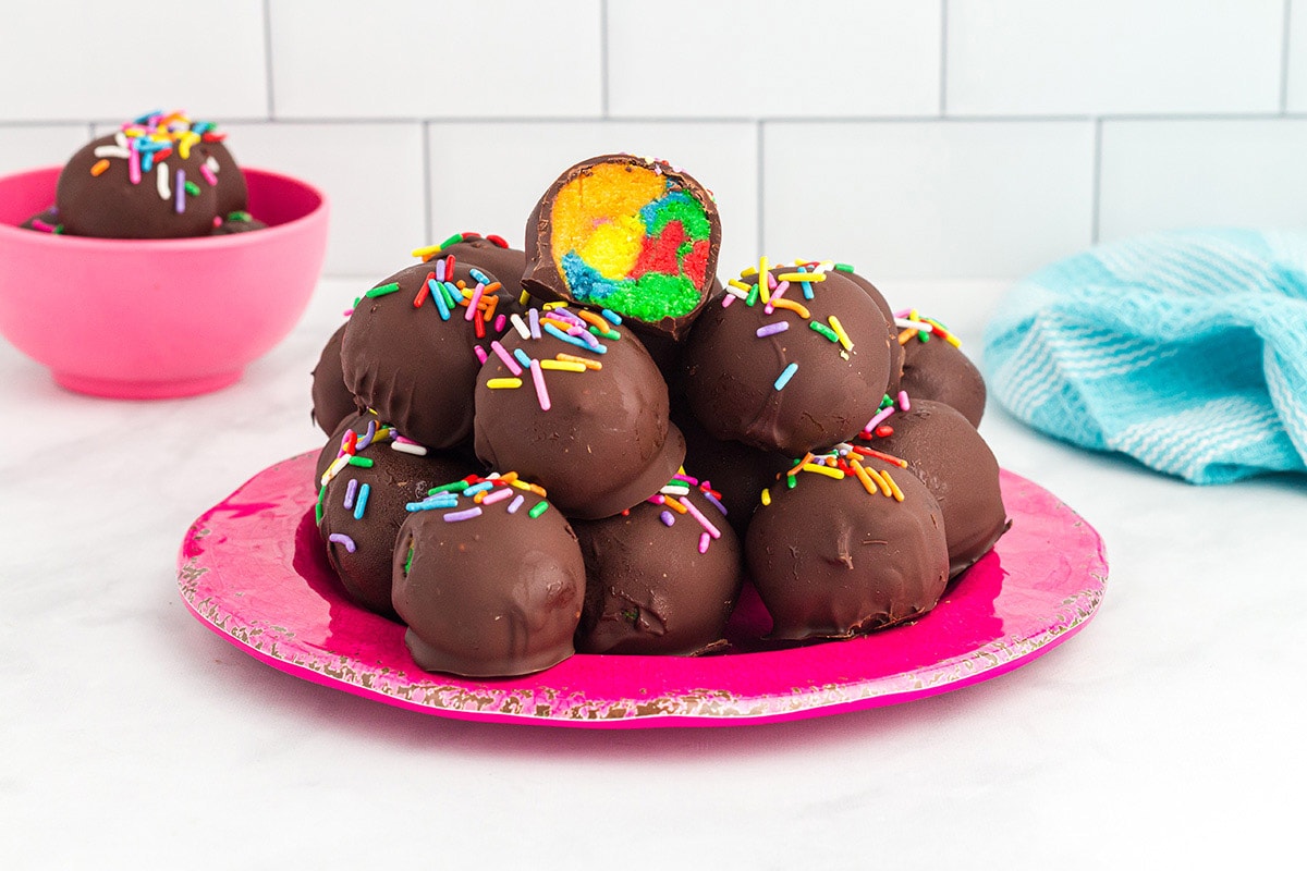 Rainbow Cake Truffles stacked up on a plate