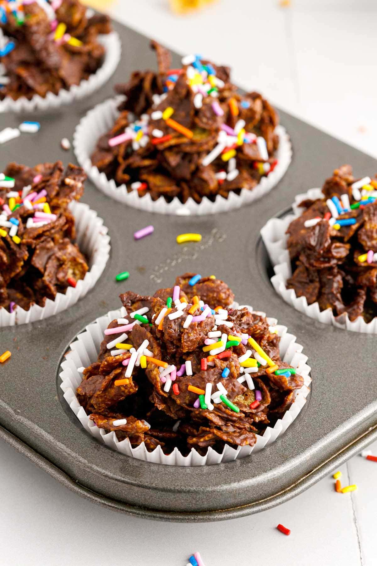 cornflake cakes in muffin tin with sprinkles