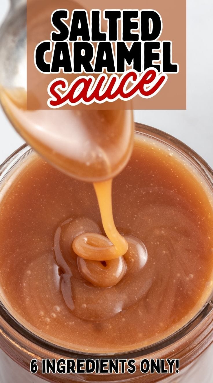 Top view of thick salted caramel sauce in a glass jar with a spoon on top of it.