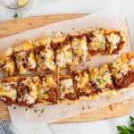 sloppy joe garlic bread on top of wooden board.