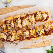 sloppy joe garlic bread on top of wooden board.