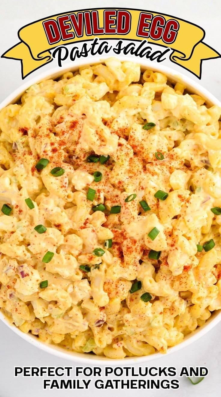 Deviled egg pasta salad with elbow macaroni, hard boiled eggs, and creamy dressing garnished with green onion in a serving bowl.