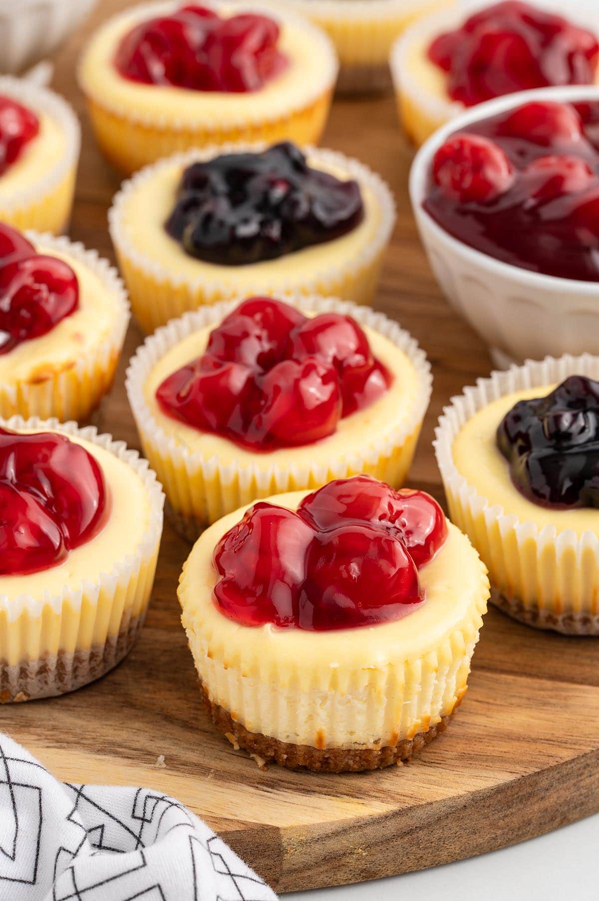 a couple mini cheesecake on top of wooden board. 