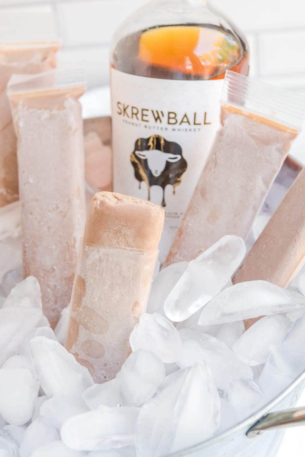 a couple of boozy pops in a bucket full of ice cubes