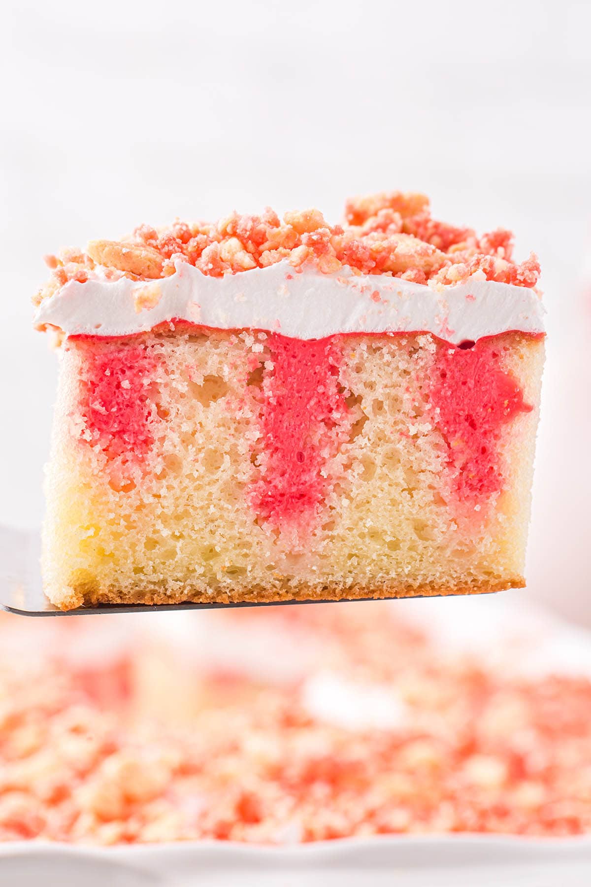a square piece of Strawberry Crunch Poke Cake