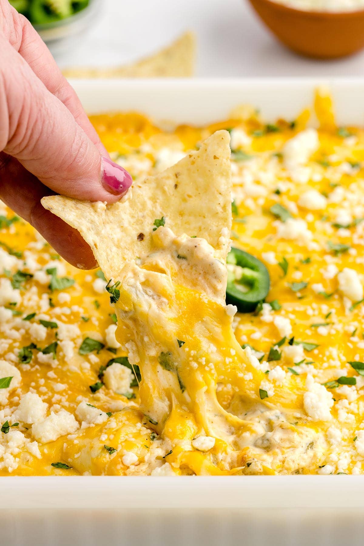 eating Mexican Street Corn Dip with tortilla chip