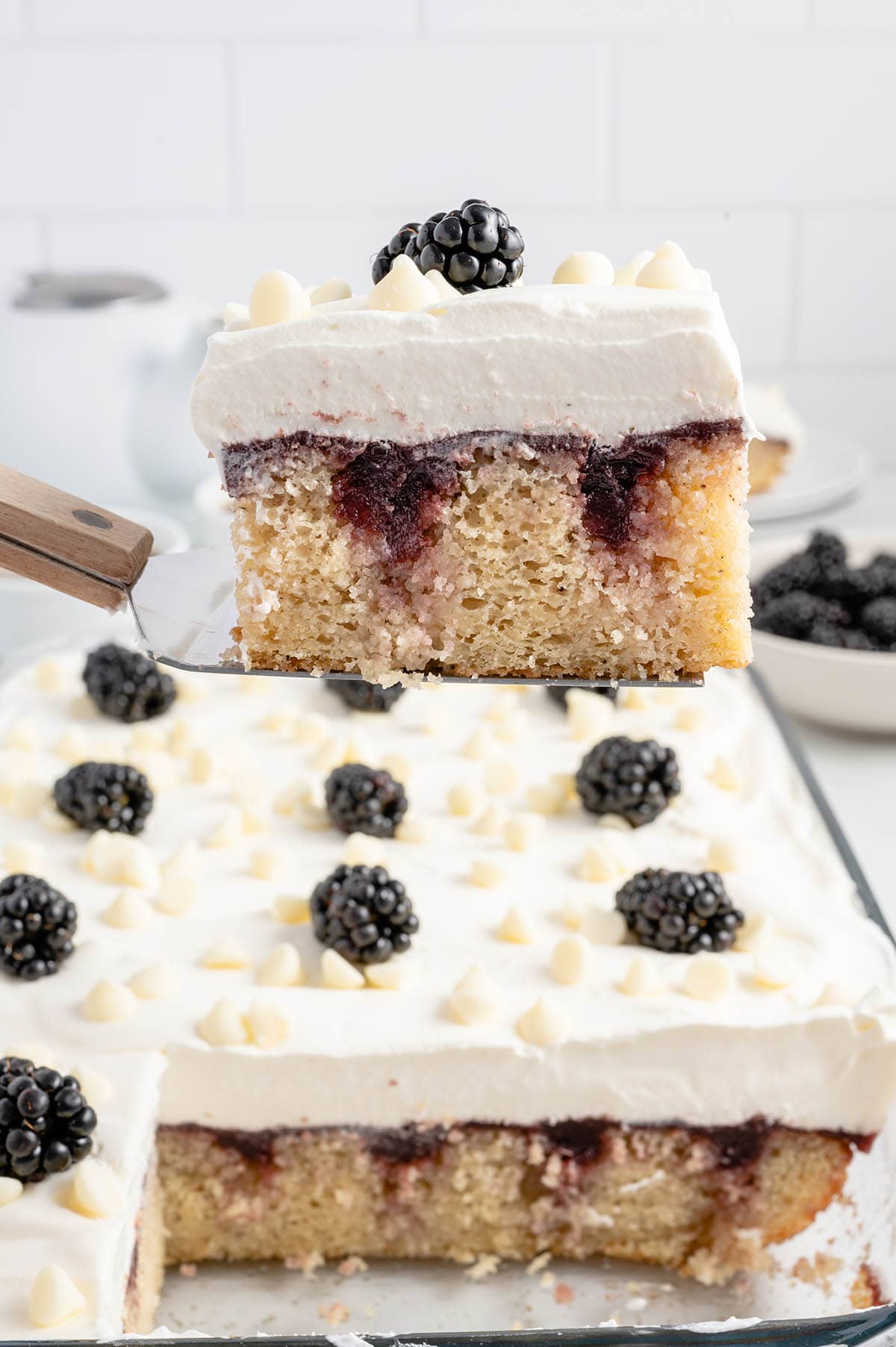 serving a square piece of Blackberry Poke Cake