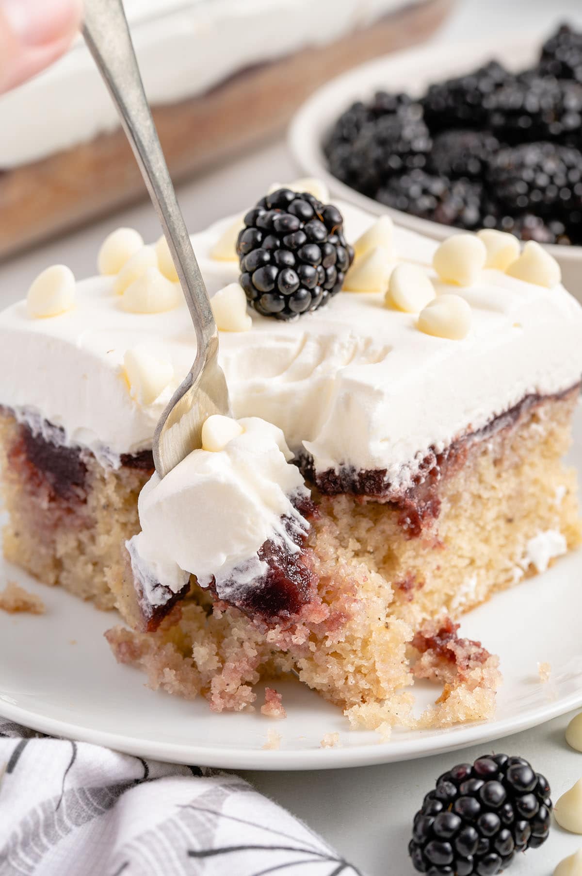 eating Blackberry Poke Cake with a fork