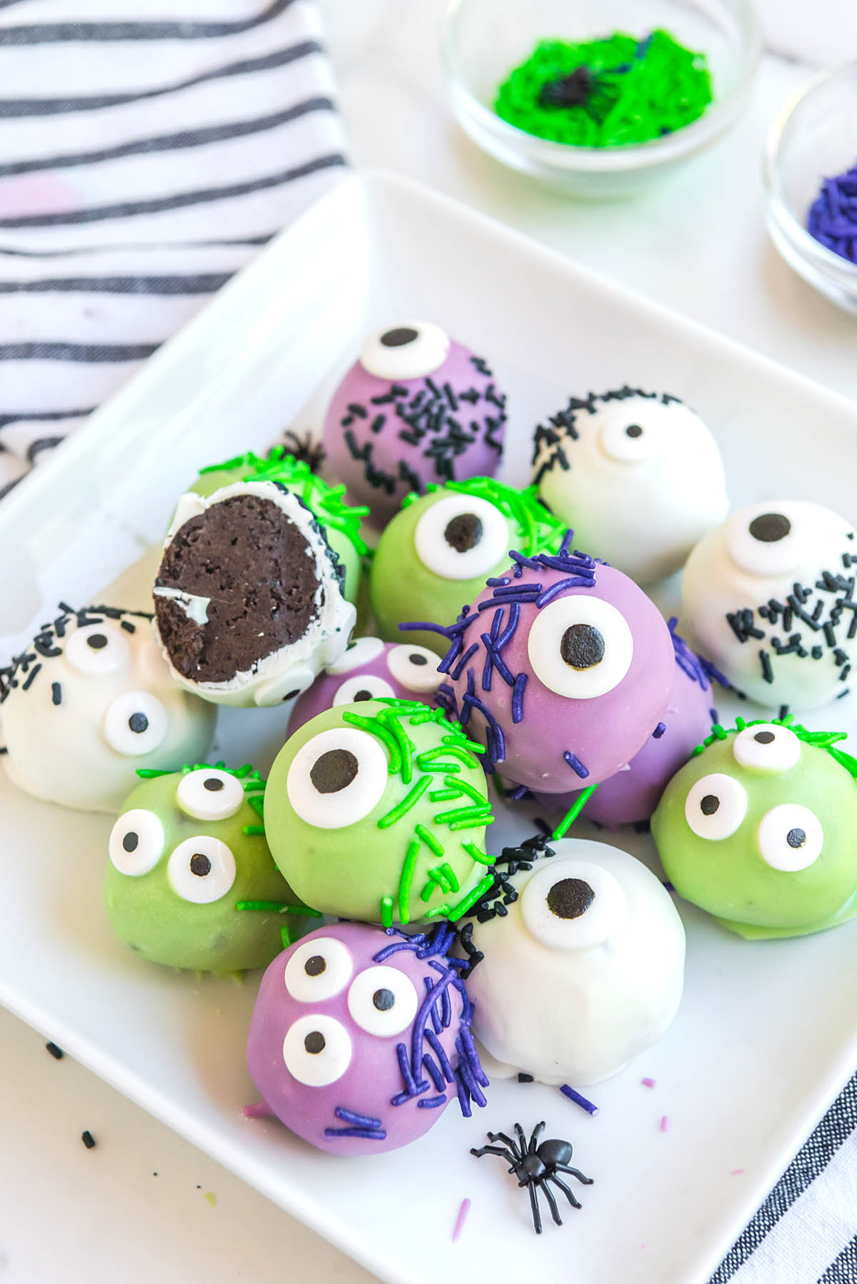 green, purple and white Monster Oreo Balls on a plate.