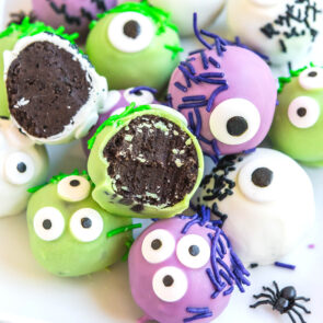 a couple of green and purple Monster Oreo Balls on a white table