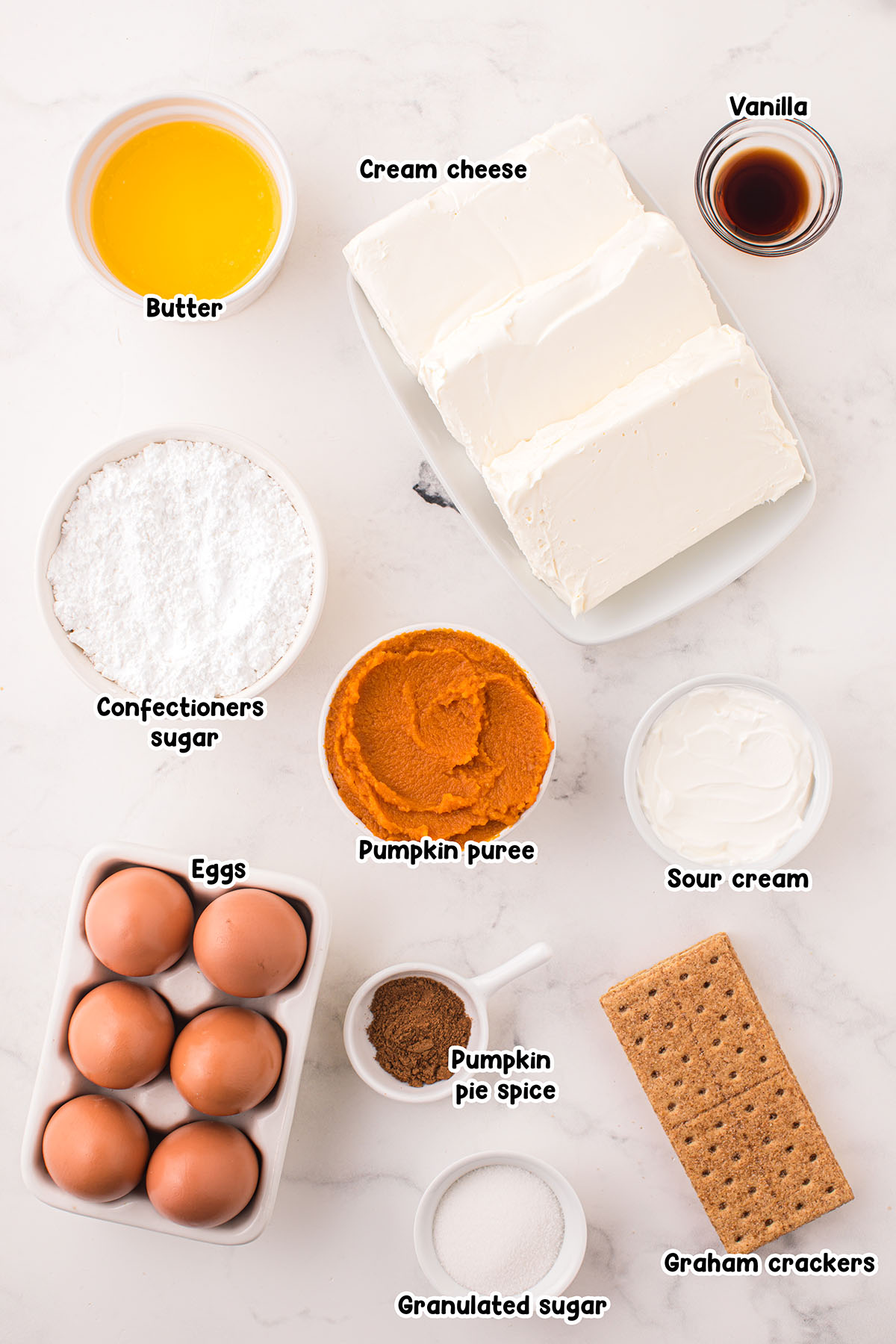 Pumpkin Cheesecake Bars ingredients. butter, vanilla, cream cheese, powdered sugar, pumpkin puree, sour cream, eggs, pumpkin spice, graham crackers, sugar