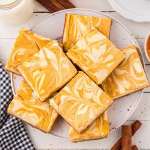 a couple of Pumpkin Cheesecake Bars on a white plate.