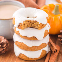 Pumpkin Donuts stacked with a bite taken out of the top one.