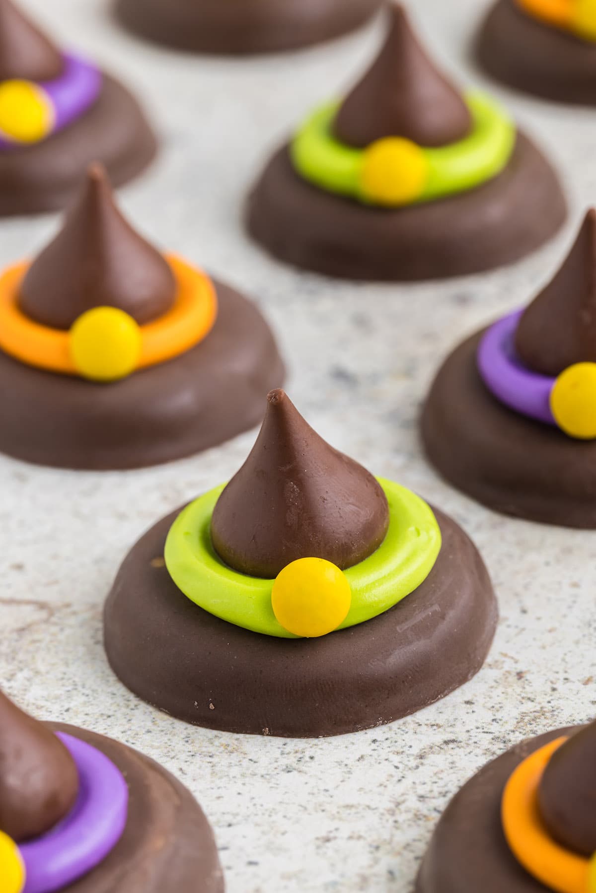 halloween witch hat cookies on top of parchment paper