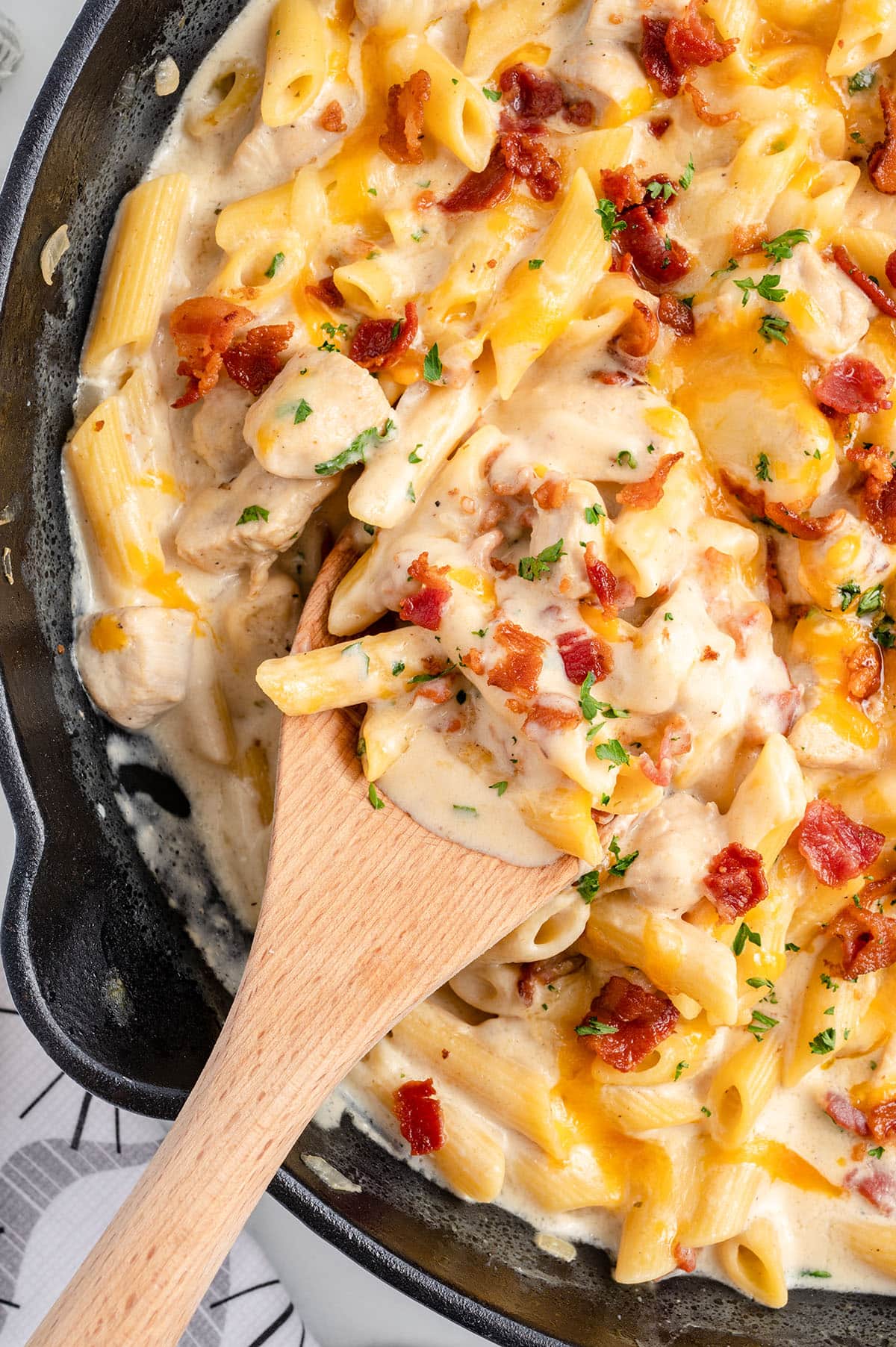Crack Chicken Penne on a skillet. and serving using a wooden spoon.