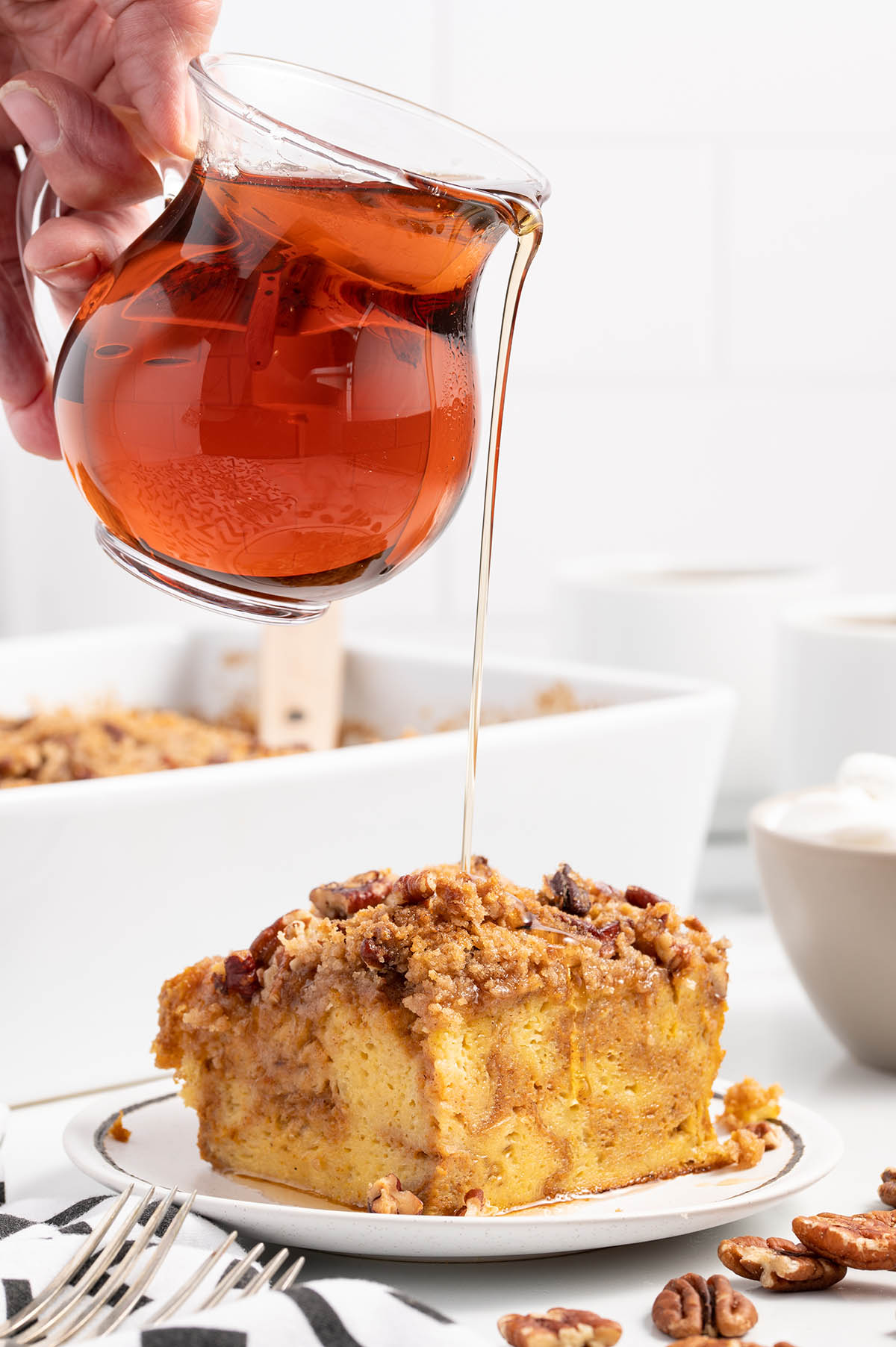 pouring maple syrup on top of Pumpkin French Toast Casserole
