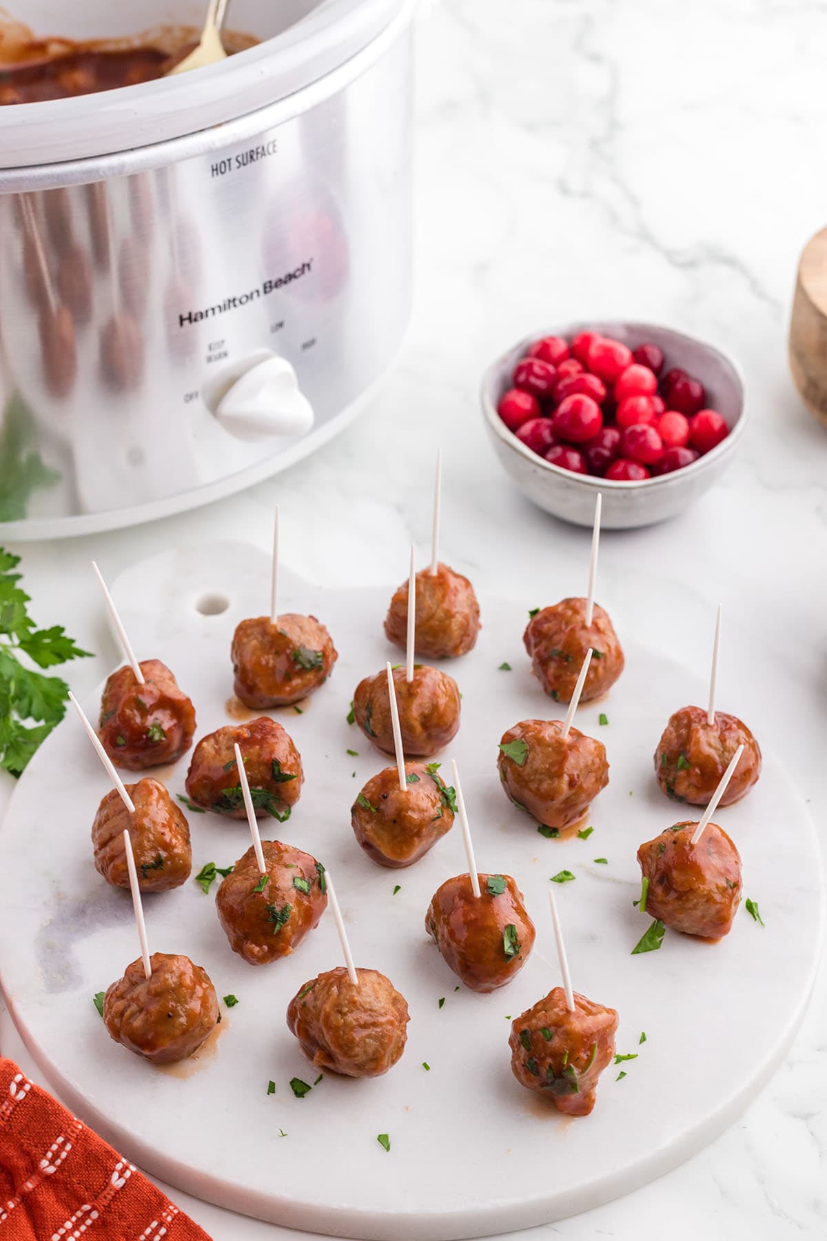 serving cranberry meatballs as finger food using toothpick.