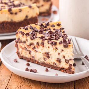 a slice of chocolate chip cheesecake on a white plate.