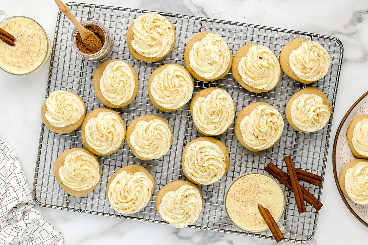 Egg Nog Cookies on a cooling rack with frosting and sprinkled with ground nutmeg.